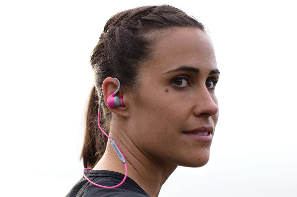 woman wearing pink and gray Wireless Bluetooth Earbuds