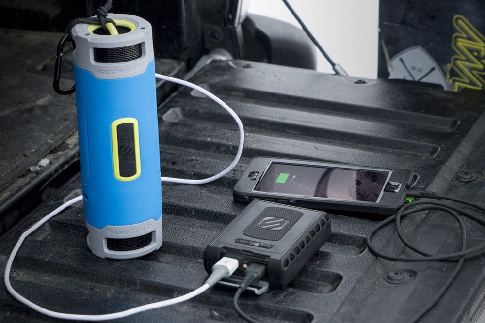 iphone and bluetooth speaker charging via Scosche portable power bank sitting on truck tailgate