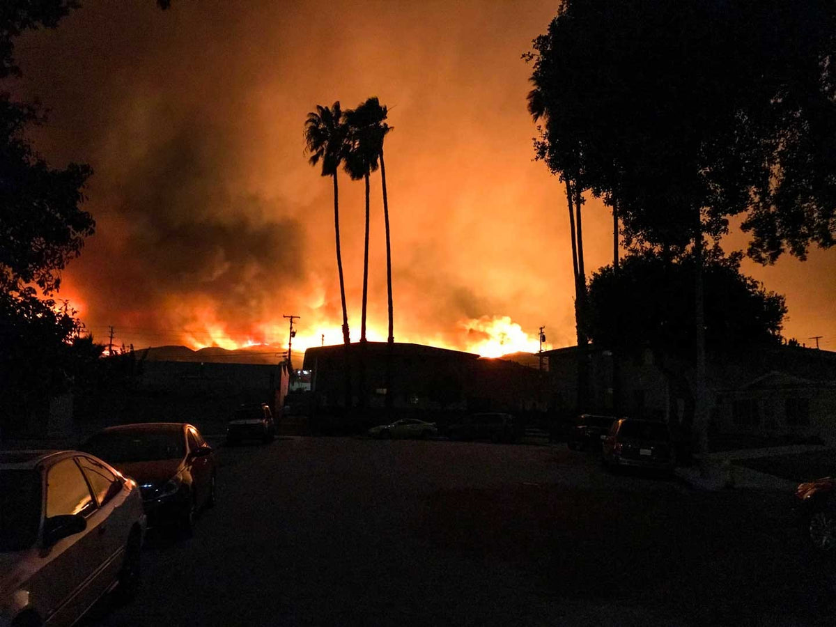 street view of neighboorhood with fire behind buildings