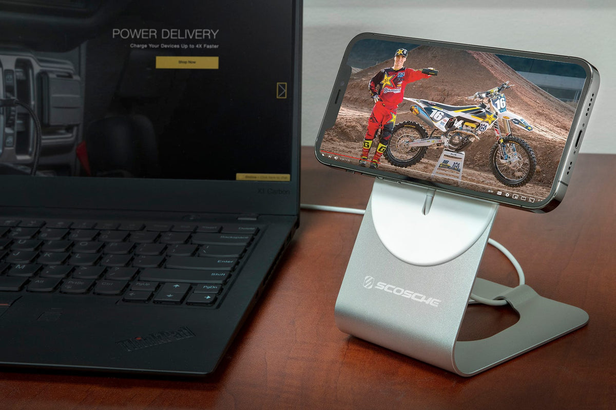 iphone charging via Scosche magsafe phone stand on table next to laptop