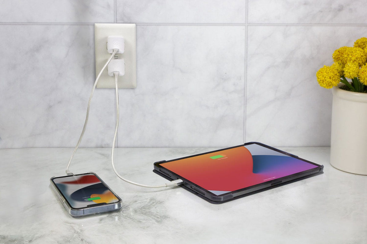 iphone and ipad sigging on counter plugged into wall socket via cable