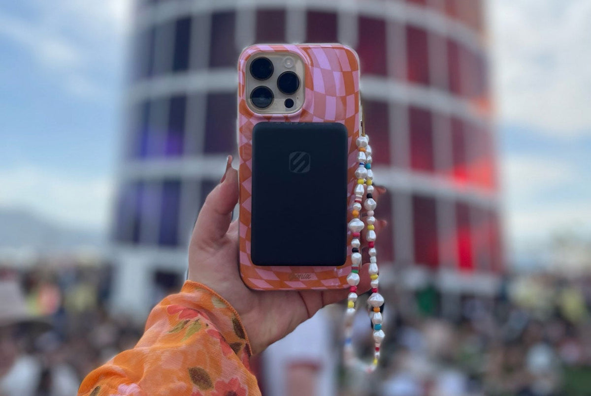 woman holding iphone for selfie with MagSafe portable charging bank attached