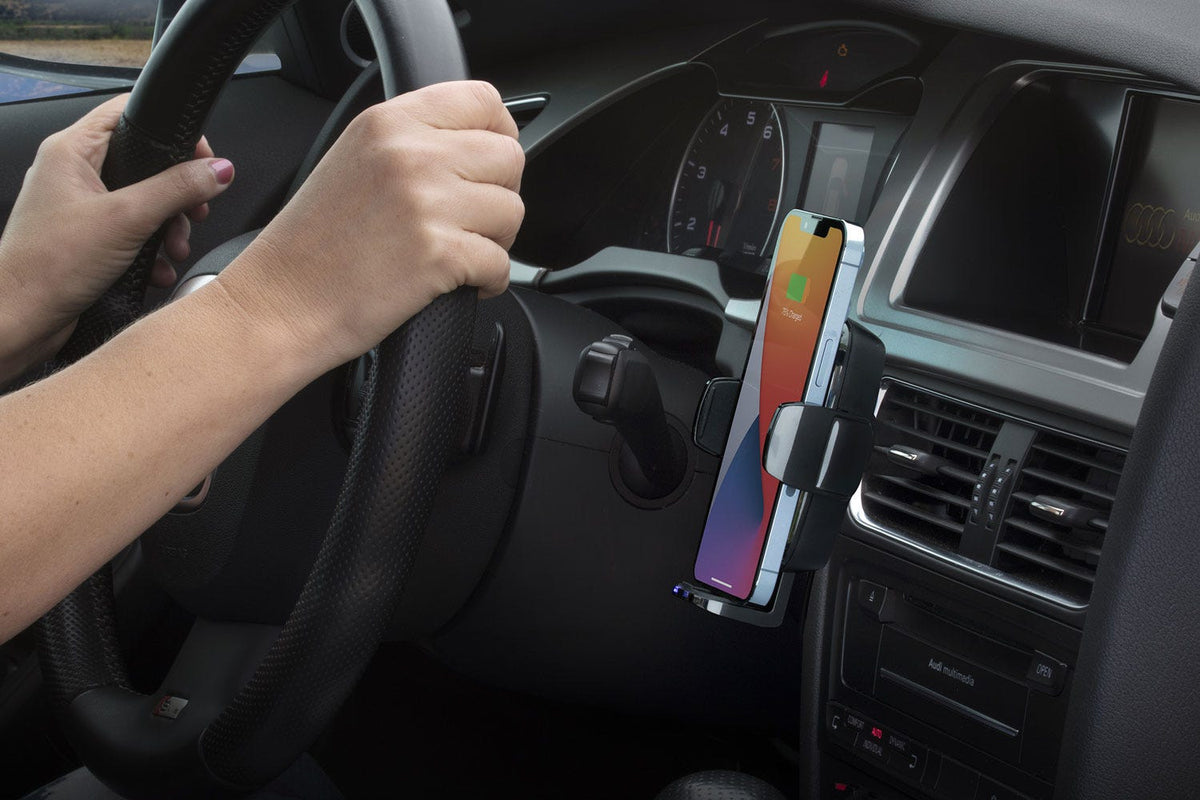 woman driving car with iphone charging via Scosche universal wireless charging vent mount