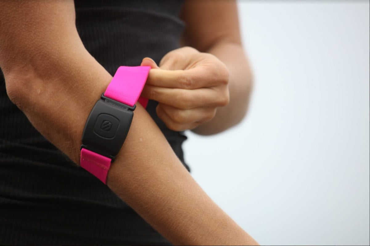close up of woman wearing pink arm band heart rate monitor