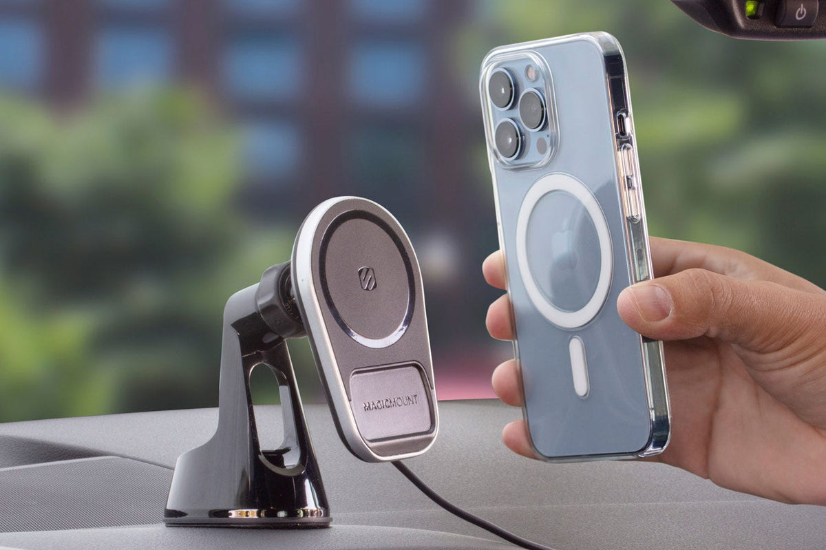 man holding iphone over MagSafe wireless charger on car dash