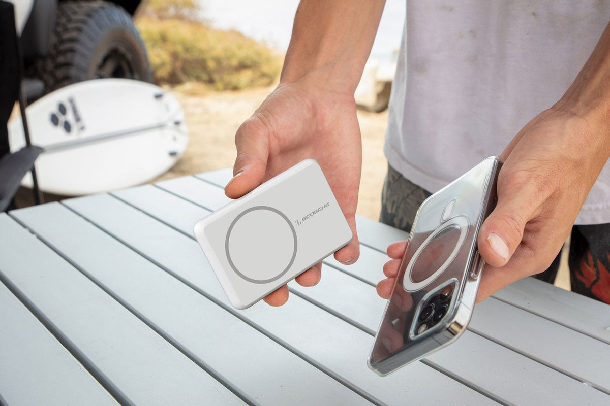 man holding iphone next to MagSafe portable power bank
