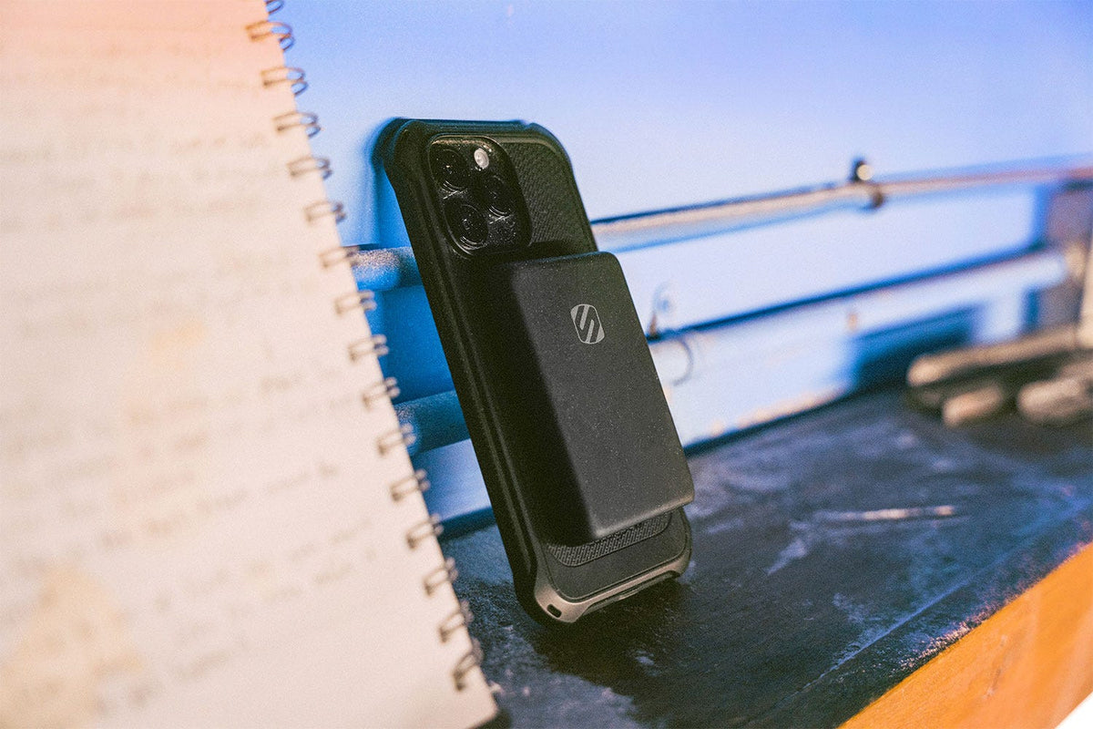 iphone with Scosche MagSafe portable power bank on boat countertop