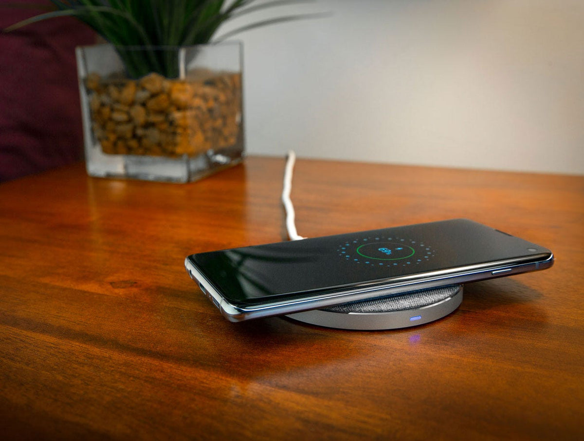 Samsung phone charging via wireless charging pad on bedside table