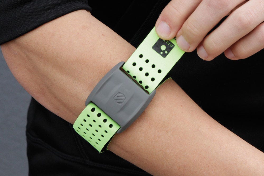 man tightening strap of armband of Scosche heart rate monitor