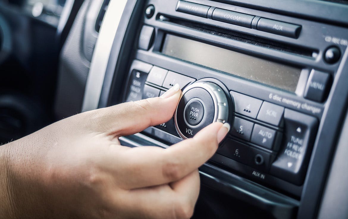 woman turning stereo button in car dash