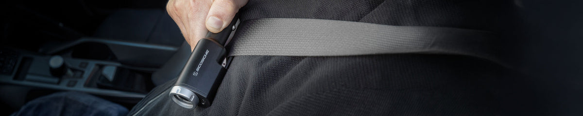Hand holding seat belt cutter multi device up to a seat belt