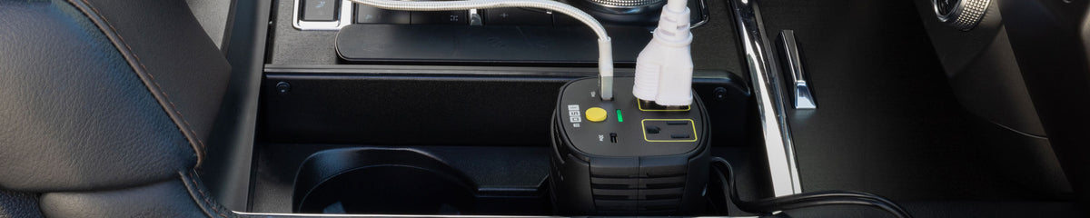 Power inverter in a cup holder in a vehicle with USB and AC plugged into it