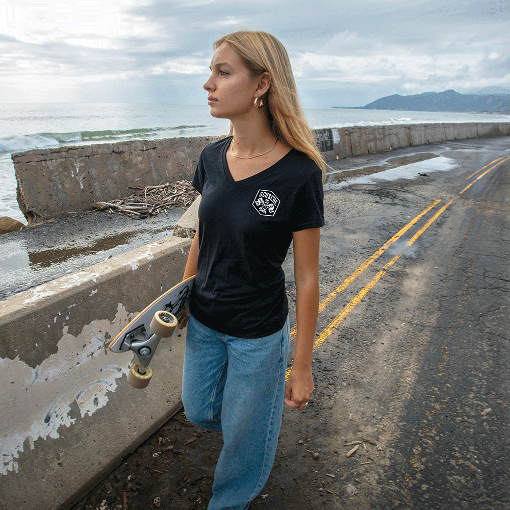 Woman walking along beach wearing Scosche Ladies' Tee with Bear Logo
