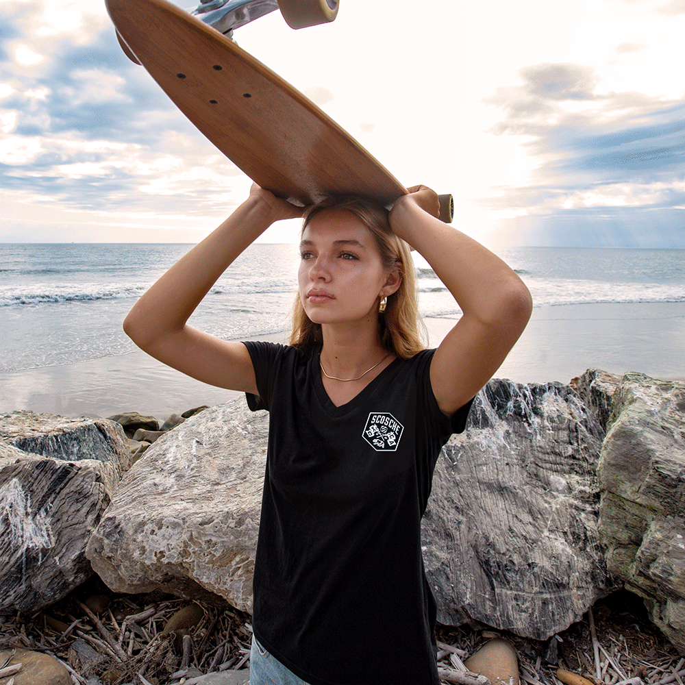Woman carrying skateboard above head wearing Scosche Ladies' Tee with Bear Logo