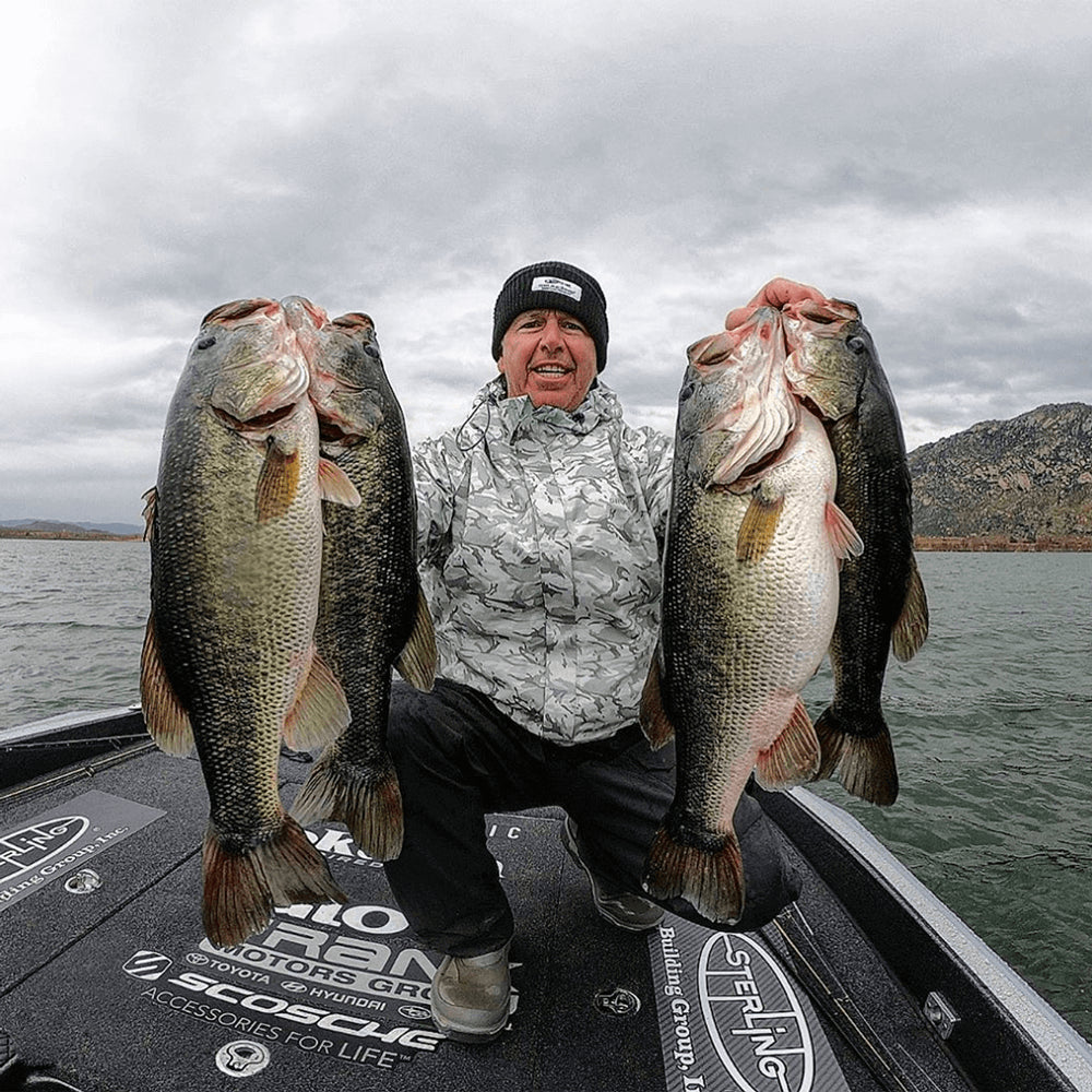 Man holding up four fish he caught