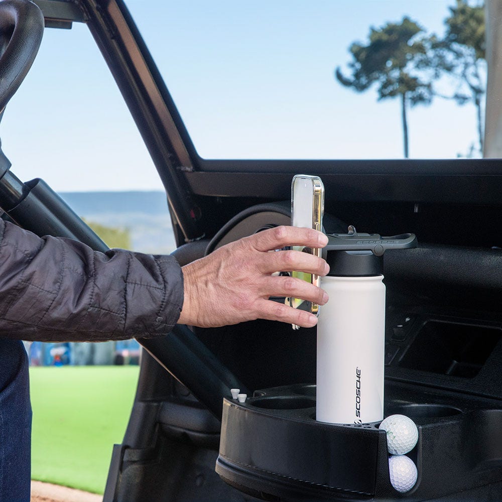 man attaching phone to water bottle in golf cart