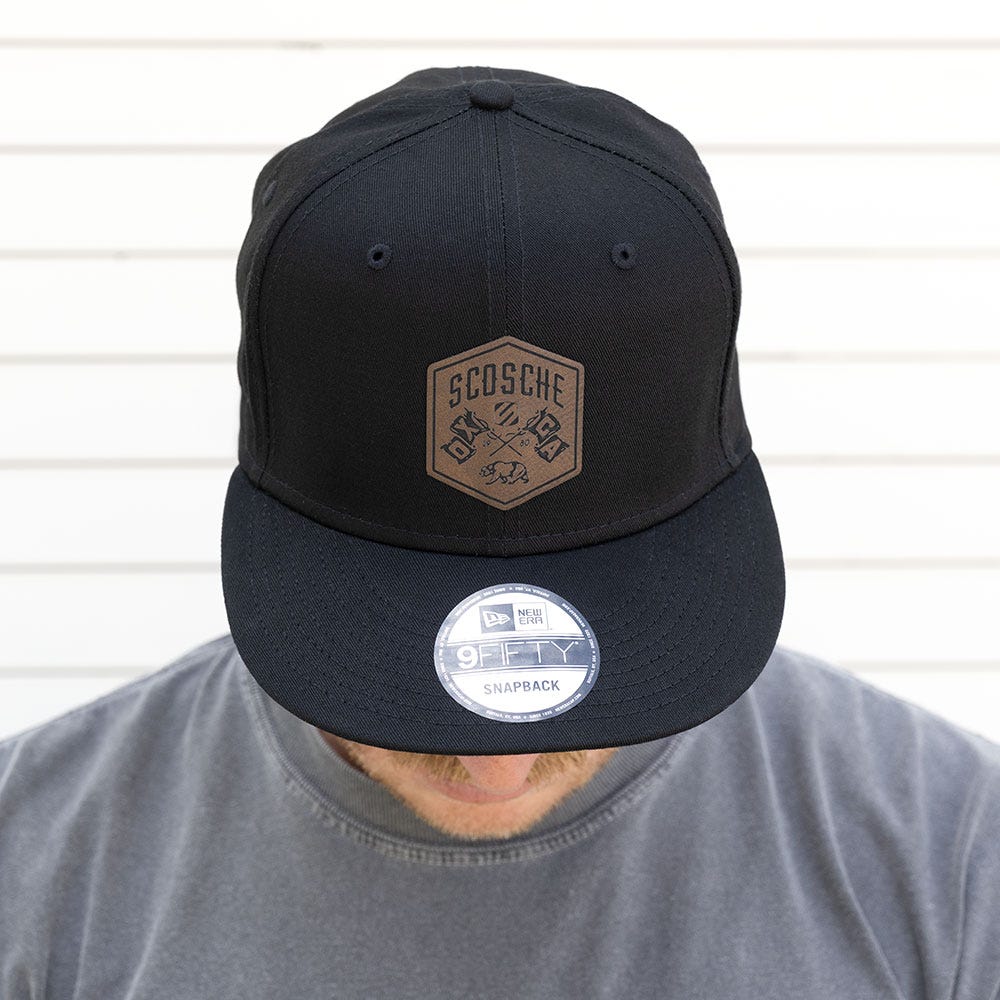 Man with head down to show black Scosche hat