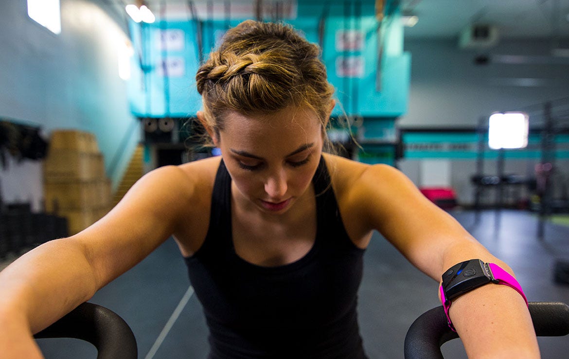 woman in gym wearing armband heart rate monitor
