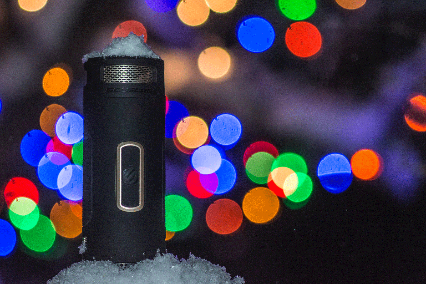 Scosche wireless bluetooth speaker with snow and christmas lights in the background
