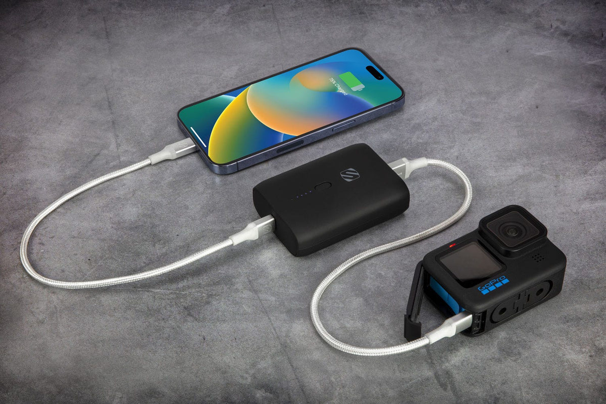 Scosche black power bank charging iphone and GoPro camera via braided cables
