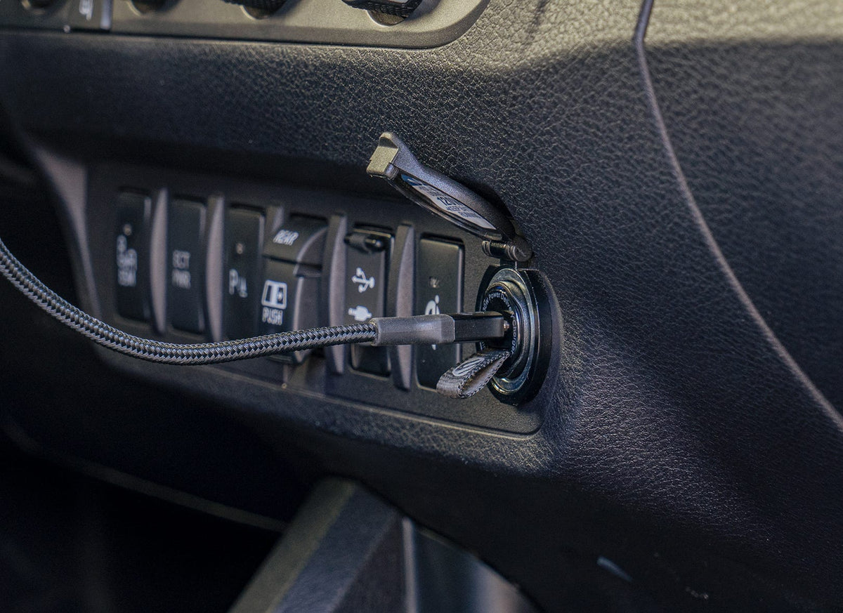 Scosche braided charging cable plugged into vehicle 12v socket
