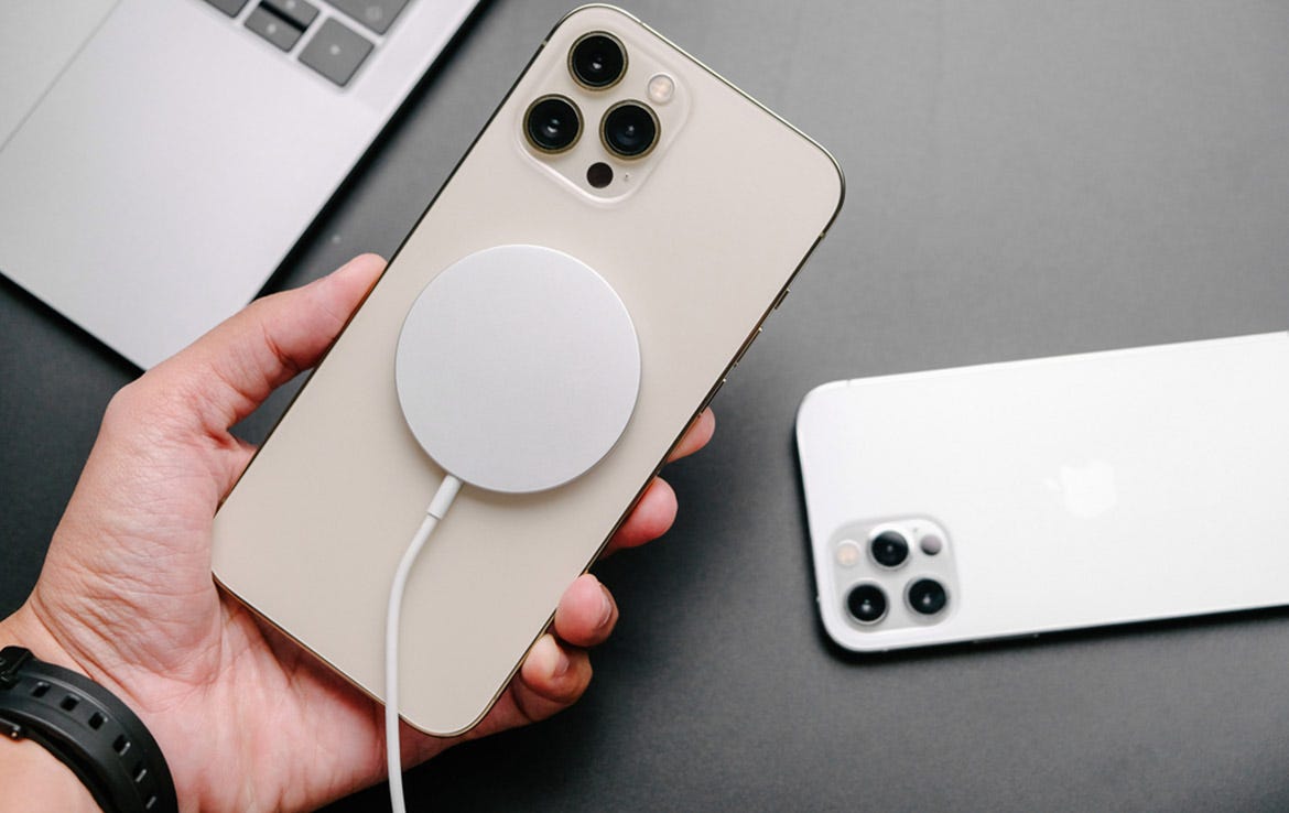 man holding iphone with white wireless charging puck