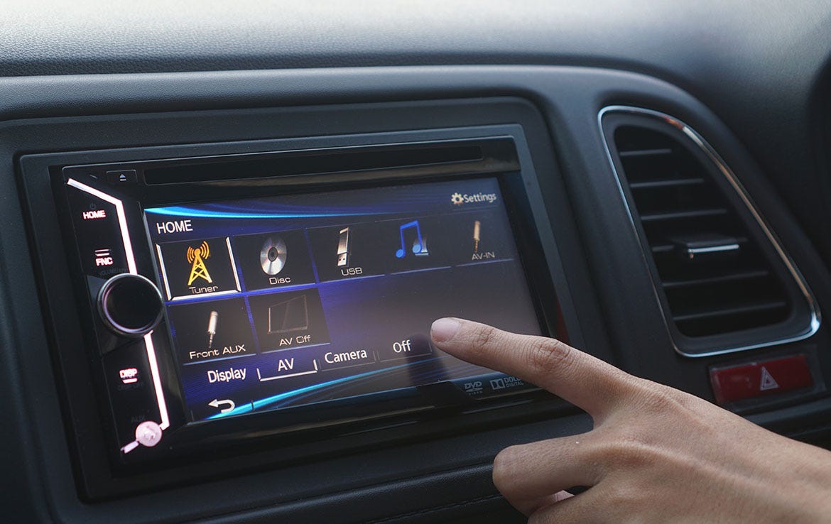 close up man touching screen of car radio in vehicle dash