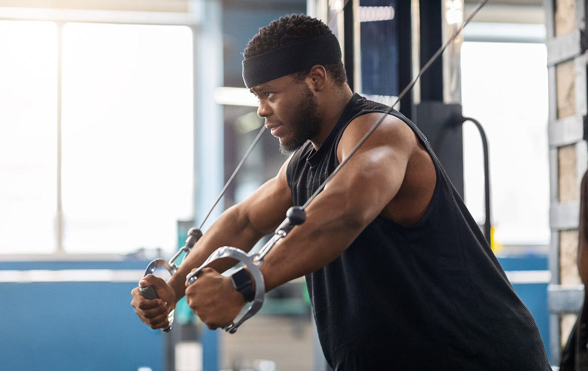 man using stacked weights for shoulders