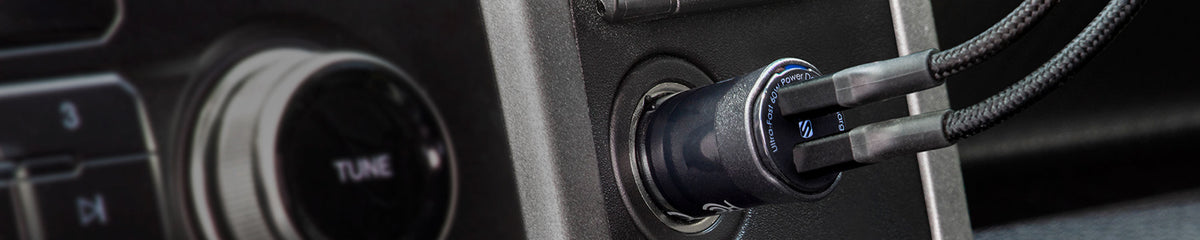 Dual Port USB-C Charger plugged into 12V outlet in a vehicle with two cables plugged into it