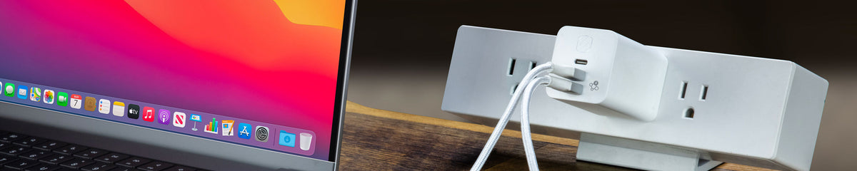 Multi-Port USB-C Charger plugged into a desk power outlet with two cables and a laptop next to it