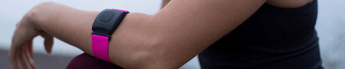 Woman's arm with a heart rate monitor on it with a pink band