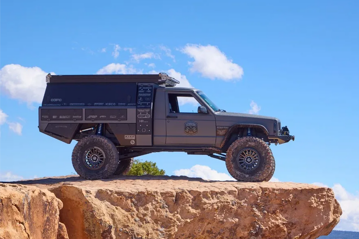 Heavily modified Jeep Commanche from the side while parked on a cliff