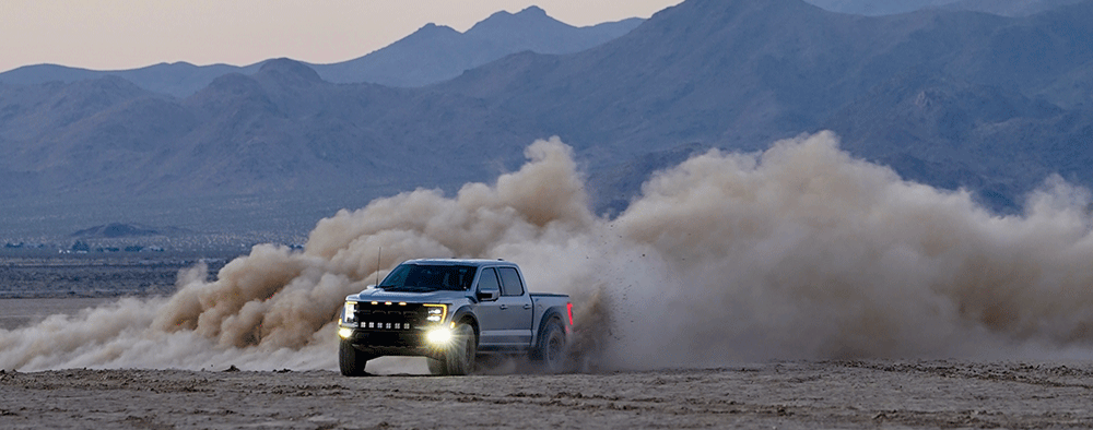 Ford F-150 Raptor making large cloud of dust in the desert