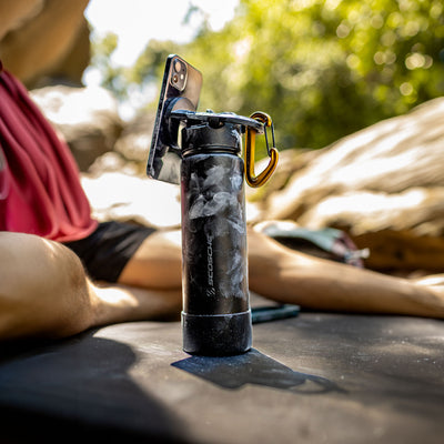 Waterbottle with phone attached with rock climber covered in chalk dust