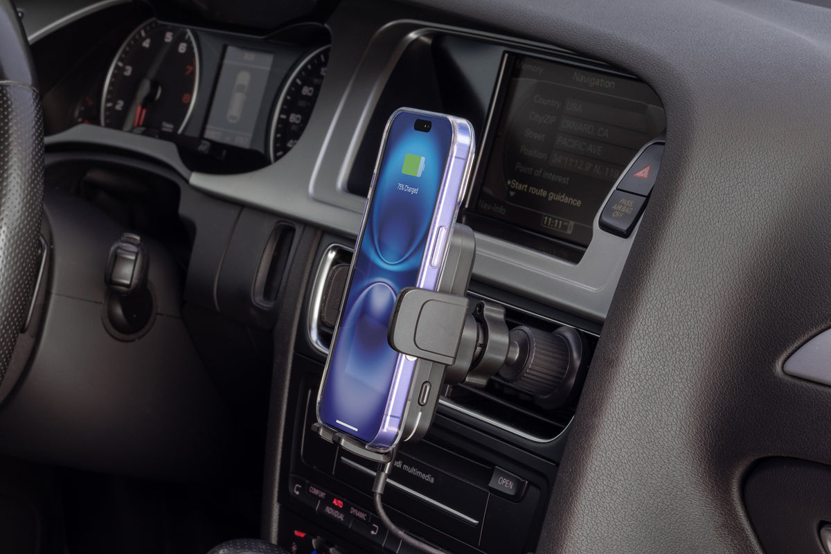 MagicGrip Charge with an iphone is mounted to the vent in a vehicle and has an iphone in its arms.