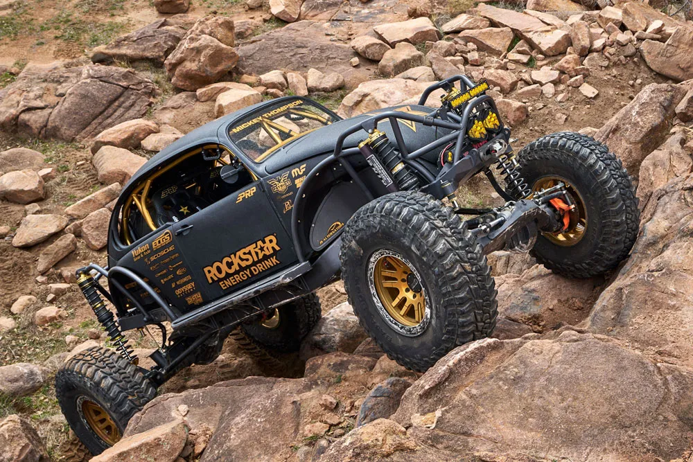 Offroad vehicle climbing up a boulder