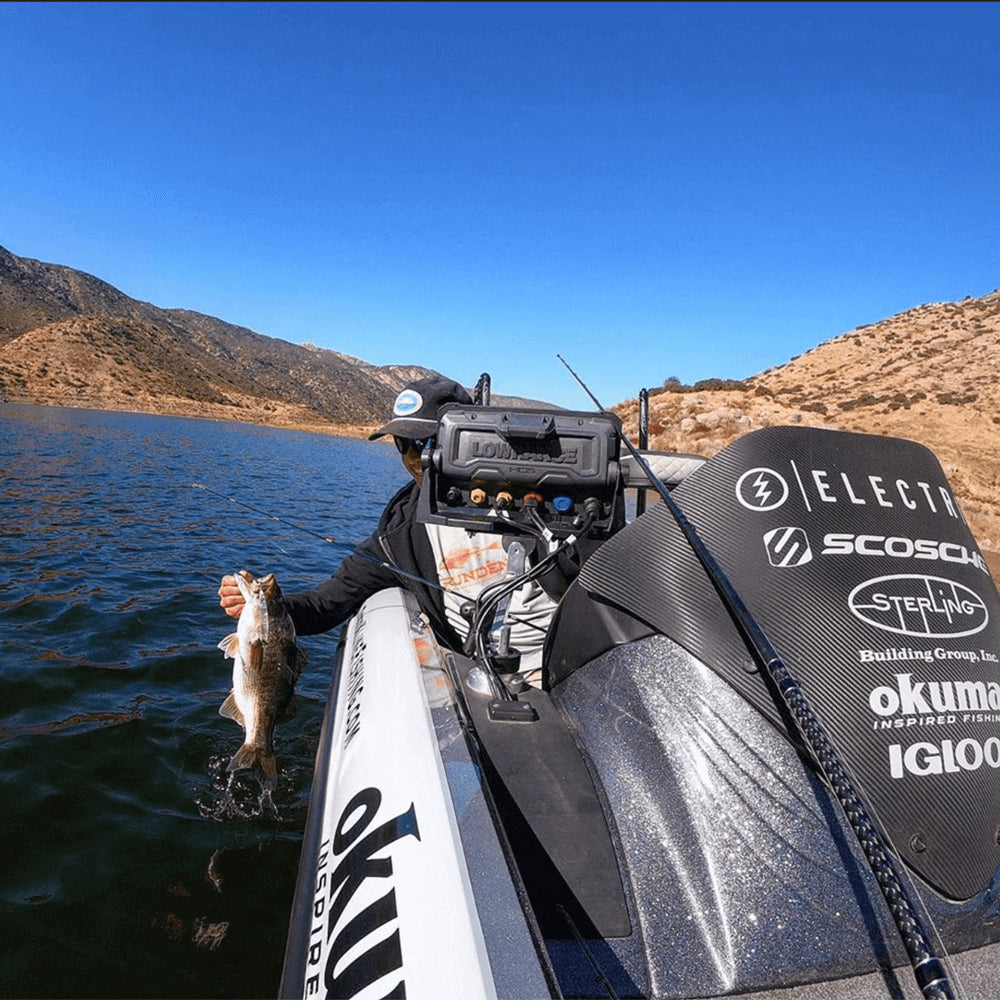 Man holding a fish over the side of a boat