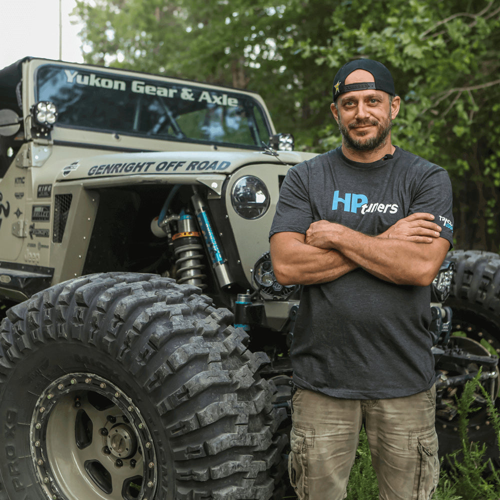 Man with arms crossed standing in front of modified Jeep Wrangler