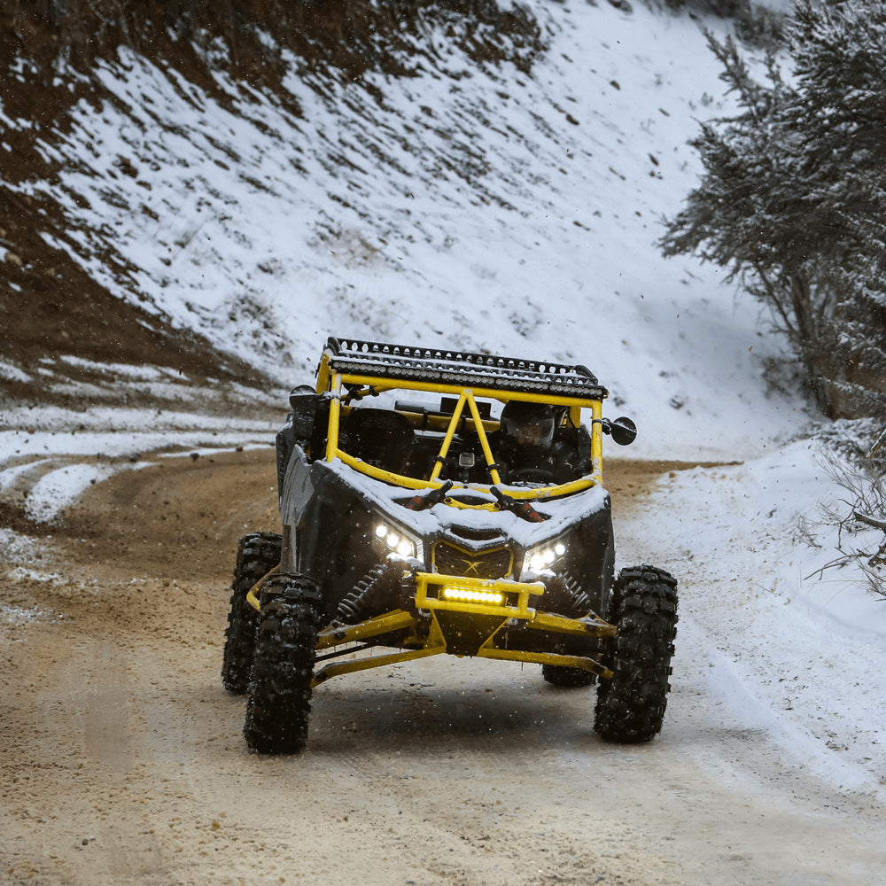 Side by side being driving offroad in snowy and muddy conditions